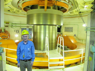 Scotsman beside 700 MW turbine, Itaipu, South America 2011