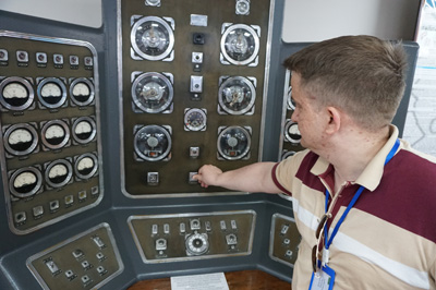 Guide demonstrating control panel, Test Center Museum, Kazakhstan 2019